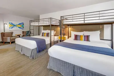 a hotel room with two beds and a chair at Hotel Becket, BW Signature Collection in South Lake Tahoe