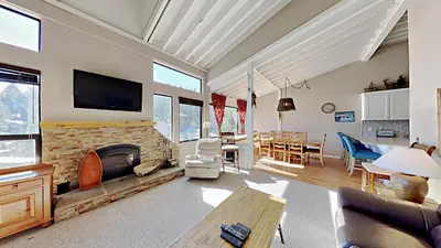 a living room with a fireplace and a dining room at Spacious 3 Bedroom Condo with Loft! in Mammoth Lakes