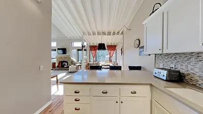 a kitchen with white cabinets and a living room at Spacious 3 Bedroom Condo with Loft! in Mammoth Lakes