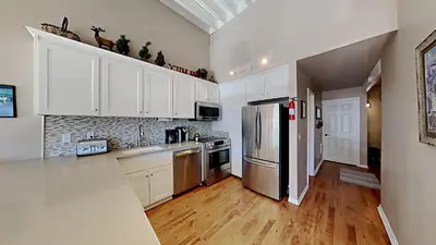 a kitchen with white cabinets and a stainless steel refrigerator at Spacious 3 Bedroom Condo with Loft! in Mammoth Lakes