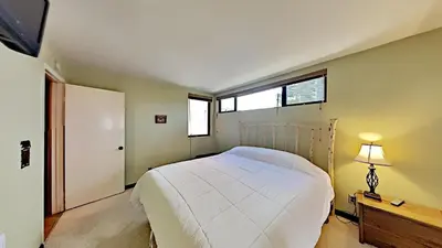 a bedroom with a white bed and a window at Great Condo With Free Shuttle to the Village! in Mammoth Lakes