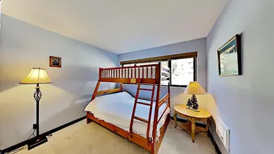 a bedroom with a bunk bed and a table and a lamp at Great Condo With Free Shuttle to the Village! in Mammoth Lakes
