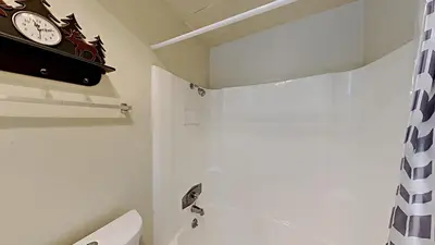 a bathroom with a clock on the wall next to a toilet at Spacious Condo Great For Friends And Families! in Mammoth Lakes