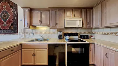 a kitchen with wooden cabinets and a black stove top oven at Comfortable 4 Bedroom Condo in Mammoth Lakes