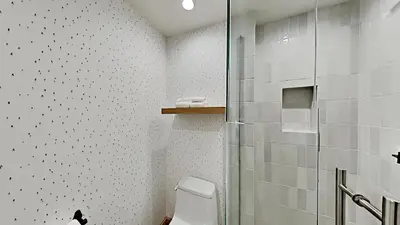 a white bathroom with a shower and a toilet at Beautifully remodeled 3 Bedroom Condo in Mammoth Lakes