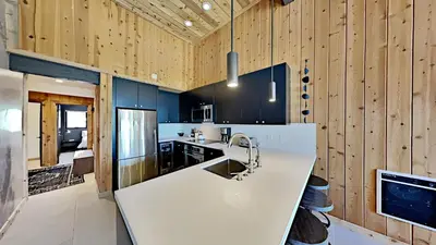 a kitchen with a white counter and wooden walls at Beautifully remodeled 3 Bedroom Condo in Mammoth Lakes