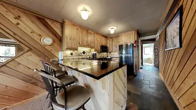 a kitchen with wooden walls and a black refrigerator at Lakeview 826 Condo #553 Condo in Mammoth Lakes