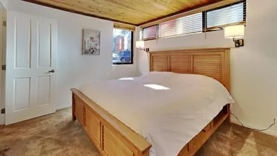 a bedroom with a large bed with a wooden headboard at Spacious 2 Bedroom Condo in Mammoth Lakes