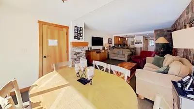 a kitchen and living room with a table and a couch at Renovated 2 Bedroom Condo with Elevator Access! in Mammoth Lakes