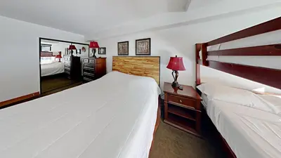 a bedroom with two beds and a mirror at Renovated 2 Bedroom Condo with Elevator Access! in Mammoth Lakes