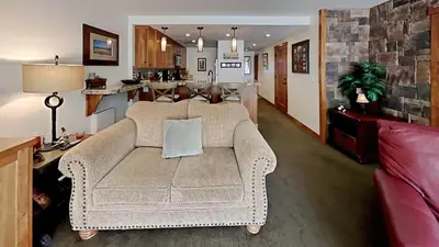 a living room with a couch and a kitchen at Renovated 2 Bedroom Condo with Elevator Access! in Mammoth Lakes