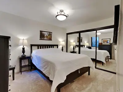 a bedroom with two beds and a large mirror at Walk To Lifts! Remodeled 2 Bedroom Condo in Mammoth Lakes