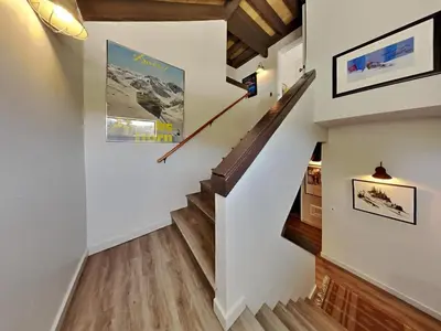 a staircase in a home with white walls and wood floors at Remodeled Spacious Cozy Condo Great For Families! in Mammoth Lakes