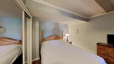 a bedroom with two beds and a tv and a mirror at Beautiful 2 BR Condo with Mountain View! in Mammoth Lakes