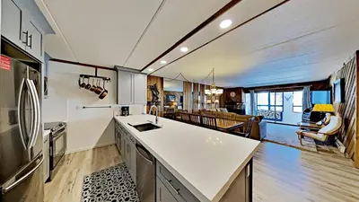 a kitchen with a white counter top and a living room at Great 3 Bedroom Condo with Washer and Dryer! in Mammoth Lakes