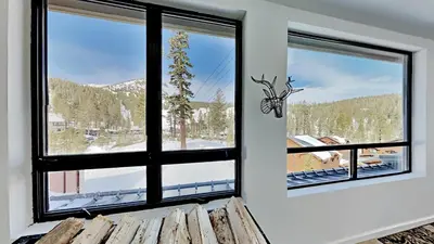 a room with two windows looking out at a snowy mountain at Great 3 Bedroom Condo with Washer and Dryer! in Mammoth Lakes
