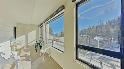 a room with a large window with tables and chairs at Comfortable Cozy 2 Bedroom Condo with Loft! in Mammoth Lakes
