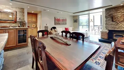 a kitchen with a wooden table and a living room at Beautiful 2 Bedroom Condo with Amazing View! in Mammoth Lakes