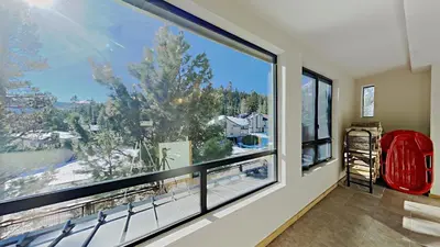 a room with a large window with a red chair in front at Retro 3 Bed 3 Bath Condo with Mountain View! in Mammoth Lakes