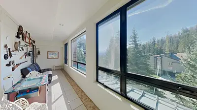 a living room with large windows and a view of the mountains at Great 2 Bedroom Condo with Mountain View! in Mammoth Lakes