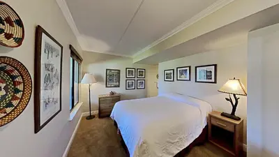 a bedroom with a white bed and pictures on the walls at 2 Bed 2 Bath Condo Steps Away From Recreation! in Mammoth Lakes