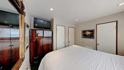 a bedroom with a bed and a tv on the wall at Beautifully Remodeled 4 Bedroom Condo in Mammoth Lakes