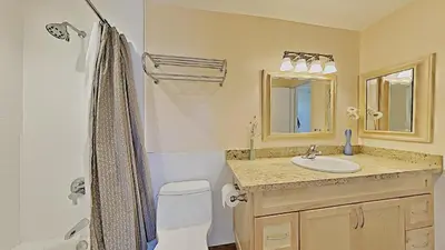 a bathroom with a sink and a toilet and a mirror at Beautiful 4 Bed Condo with Top Of The Hill Views! in Mammoth Lakes