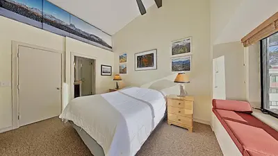 a bedroom with a bed and a red couch at Beautiful 4 Bed Condo with Top Of The Hill Views! in Mammoth Lakes
