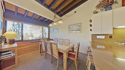 a kitchen and dining room with a table and chairs at Beautiful 4 Bed Condo with Top Of The Hill Views! in Mammoth Lakes