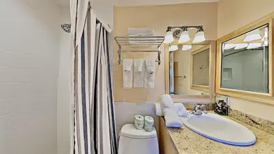 a bathroom with a sink and a toilet and a mirror at Beautiful 4 Bed Condo with Top Of The Hill Views! in Mammoth Lakes