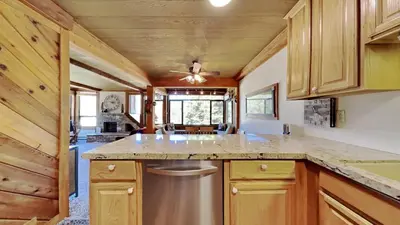 a kitchen with wooden cabinets and a large counter top at Nicely Remodeled 2 Bedroom Condo in Mammoth! in Mammoth Lakes