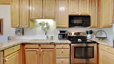 a kitchen with wooden cabinets and a stove top oven at Nicely Remodeled 2 Bedroom Condo in Mammoth! in Mammoth Lakes