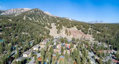an aerial view of a mountain with trees and buildings at Cozy 4-Bedroom Home with Pool and Mountain View! in Mammoth Lakes