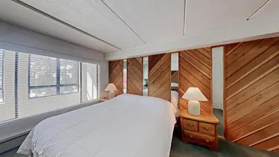 a bedroom with a large white bed and a window at Comfortable 2 Bed Condo, Easy Access to Slopes! in Mammoth Lakes