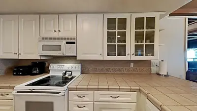 a kitchen with white cabinets and a stove top oven at Comfortable 2 Bed Condo, Easy Access to Slopes! in Mammoth Lakes