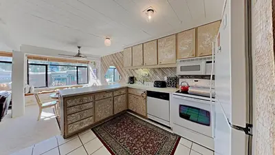 a kitchen with white appliances and a large window at Upgraded 2 Bedroom Condo with Pool in Mammoth Lakes