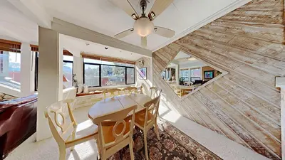 a dining room with a ceiling fan and a wooden wall at Upgraded 2 Bedroom Condo with Pool in Mammoth Lakes