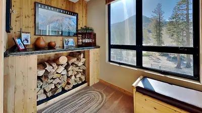 a room with a fireplace with a tv and a window at Lakeview 826 Condo #302 Condo in Mammoth Lakes