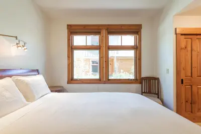 a bedroom with a white bed and a window at Cabins 13 in Old Mammoth