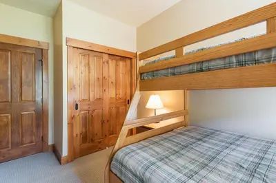 a bedroom with two bunk beds and a door at Cabins 21 in Old Mammoth
