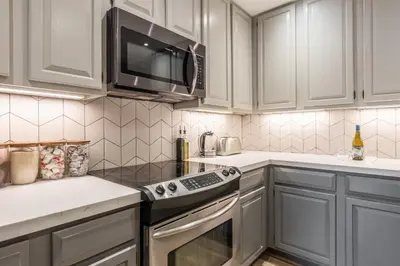 a kitchen with white cabinets and a microwave at Canyon Ski and Racquet 16 in Mammoth Lakes