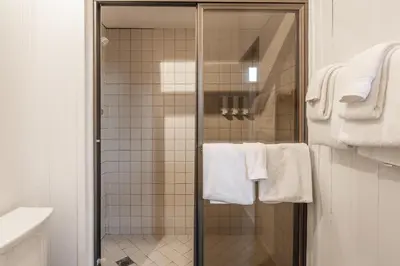 a bathroom with a shower with white towels at Canyon Ski and Racquet 16 in Mammoth Lakes