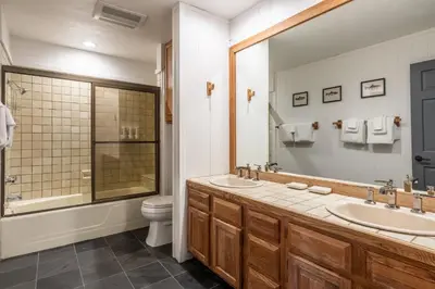 a bathroom with two sinks and a toilet at Canyon Ski and Racquet 16 in Mammoth Lakes