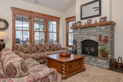 a living room with couches and a stone fireplace at Lodges 1140- Spacious Townhome on Golf Course in Old Mammoth