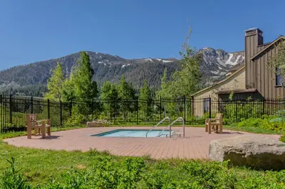 a pool with a slide and two benches in a yard at Lodges 1140- Spacious Townhome on Golf Course in Old Mammoth