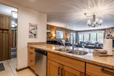 a kitchen with a sink and a living room at Mountainback 15 in Old Mammoth