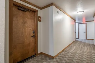 a hallway with a wooden door and a tile floor at Mountainback 15 in Old Mammoth