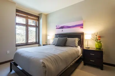 a bedroom with a large bed and two windows at Solstice 21 in Mammoth Lakes