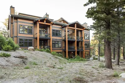 a large house on top of a hill with trees at Solstice 21 in Mammoth Lakes