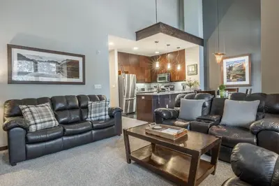 a living room with leather couches and a table at Solstice 21 in Mammoth Lakes